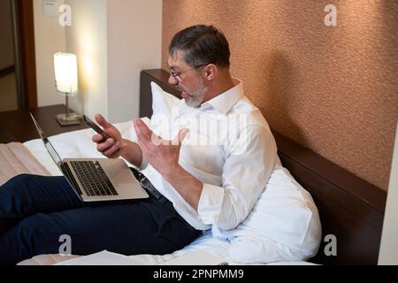 Ein Mann in einer stressigen Situation, der von zu Hause aus arbeitet Stockfoto
