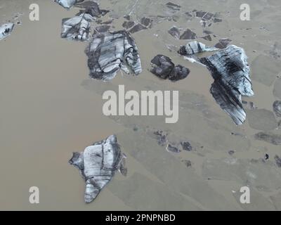 Luftaufnahme der atemberaubenden Solheimajokull Gletscherlagune in Island mit schwimmenden Eisbergen in den majestätischen Gewässern Stockfoto