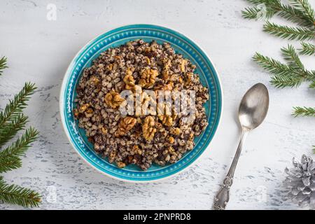 Traditionelles russisches Weihnachtsgericht Sochivo aus Perlgerste, Mohnsamen, Walnüssen, Rosinen und Honig, dekoriert mit Weihnachtsbaumzweigen auf einem Stockfoto