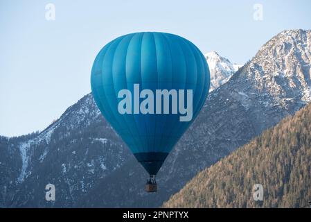 una bella mongolfiera prende il volo bei una limpida mattinata in montagna nelle dolomiti Stockfoto