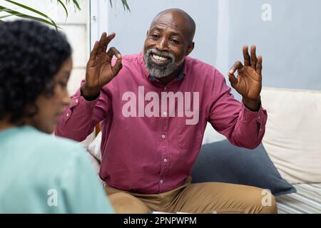 Glücklicher afroamerikanischer Patient, der mit einer birassischen Therapeutin zur Therapie geht Stockfoto
