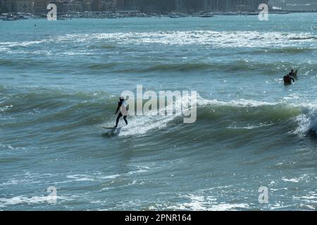 Drei Surfer surfen in Golfo dei Poeti, (Golf der Dichter), Ligurien, Italien Stockfoto