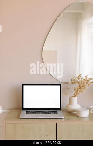 Öffnen Sie einen Laptop mit einem leeren Bildschirm auf einem Sideboard im Wohnzimmer Stockfoto