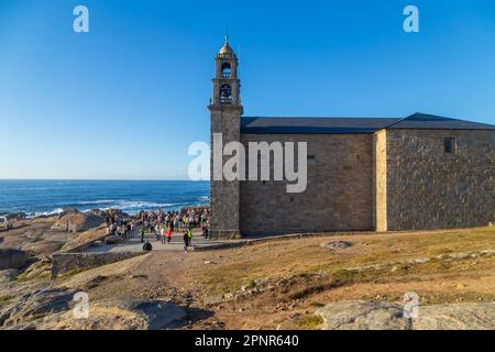 Muxia, A Coruna - Spanien; 30. August 2022: Virxe de la Barca Sanctuary an der Atlantikküste Felsen im Vordergrund Nachmittagslicht Stockfoto