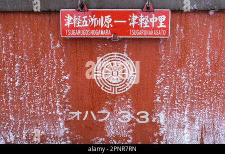 Ein Schild mit den Zielen der Tsugaru Railway in der Präfektur Aomori, Japan, das an einem verschneiten Wintertag an einer Seite eines Eisenbahnwaggons angebracht ist. Stockfoto