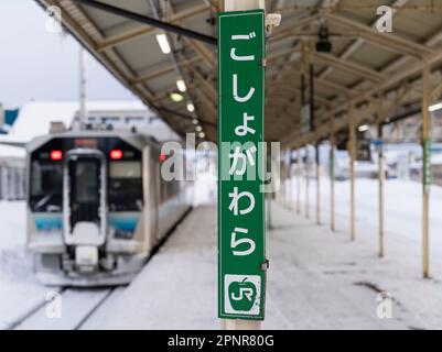 Ein Schild zum Bahnhof Goshogawara in der Präfektur Aomori, Japan, im Winter auf dem Bahnsteig zu sehen. Stockfoto