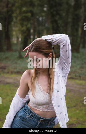 Nahaufnahme einer Tänzerin während einer Bewegung im Park. Regenwetter. Stockfoto