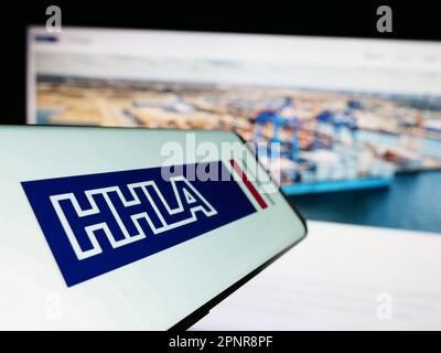 Handy mit Logo der Firma Hamburger Hafen und Logistik AG (HHLA) auf dem Bildschirm vor der Website. Fokus auf die Mitte links des Telefondisplays. Stockfoto