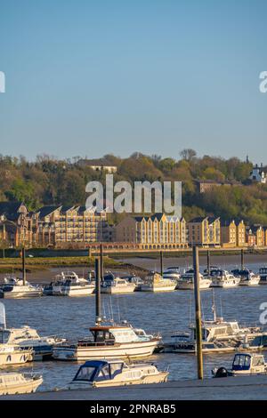 Unterkünfte am Flussufer des Medway in Rochester Kent mit festgefahrenen Booten auf dem Medway Stockfoto