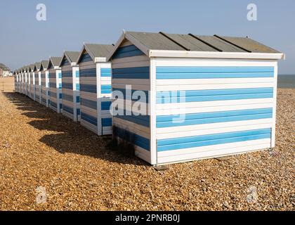 Blau gestreifte Strandhütten auf Kieseln Stockfoto