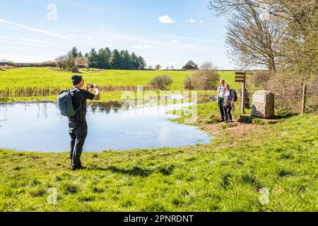 Menschen am Anfang des Themsenpfads an der Quelle der Themse bei Thames Head in den Cotswolds bei Kemble, Gloucestershire, Großbritannien. Stockfoto