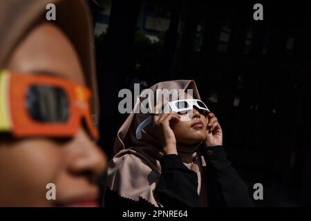 Bandung, Indonesien. 20. April 2023. Ein Student trägt Sonnenfinsternbrille, während er die hybride partielle Sonnenfinsternis in Bandung, West Java, Indonesien, beobachtet, 20. April 2023. (Foto: Dimas Rachmatsyah/INA Photo Agency/Sipa USA) Guthaben: SIPA USA/Alamy Live News Stockfoto