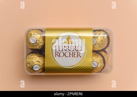 Arahal. Sevilla. Spanien. 18. März 2023. Stillleben mit einer Schachtel Ferrero-Rocher-Schokolade auf hellorangefarbenem Hintergrund. Übermäßiger Zuckerkonsum Stockfoto