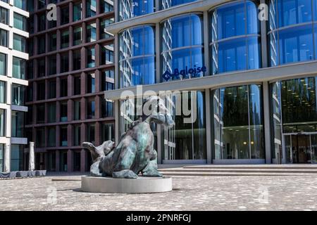 Basel, Schweiz - August 10. 2021: Die bronzene imaginäre Schnupftierfigur im Baloise Park mit hohen Geschäftsgebäuden hinter dem ce Stockfoto