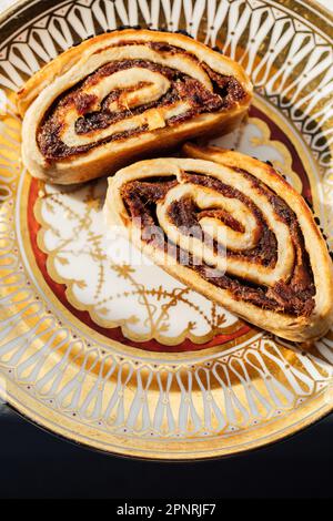 Kleicha, irakische Datteln Kekse in spiralförmiger Form mit Nigellasamen auf einer kunstvoll verzierten goldenen Platte Stockfoto