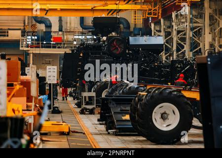 Industriearbeiter montieren landwirtschaftliche Erntemaschinen in der Werkstatt. Stockfoto