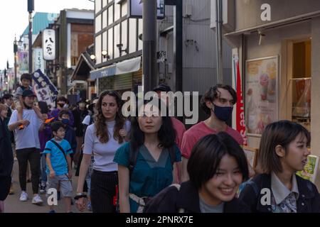 Touristen und Einheimische gehen durch die Komachi Straße in Kamakura. Nach dreieinhalb Jahren Covid-19-Pandemie sind internationale Touristen nach Japan und seinen berühmten Reisezielen zurückgekehrt. Stockfoto