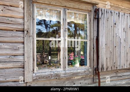 Holzwände, Fenster und Reflexionen im Glas. Sommer auf dem Land. Stockfoto