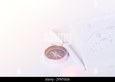 Reisenotizen. Ein sauberes Notizbuch mit Stift zum Schreiben eines Kompasses und einer Karte. Das Konzept des Reisens. Stockfoto