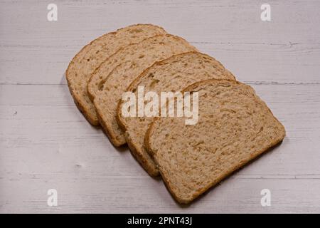 Vier Scheiben braunes Haferflocken auf einem Holzbrett Stockfoto