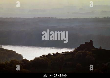 Neblige Landschaft über Wald mit Silhouette der alten Ruinen der Burg Devin und der Donau mit österreichischen Ebenen in der Ferne Stockfoto