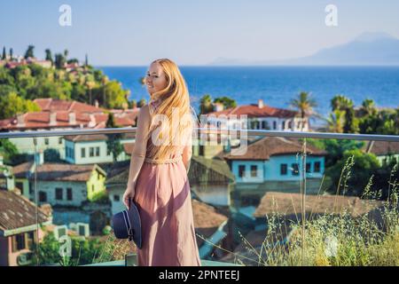 Touristenfrau in der Altstadt von Kaleici in Antalya. Turkiye. Panoramablick auf den Hafen der Altstadt von Antalya, das Taurusgebirge und das Mittelmeer, Türkei Stockfoto