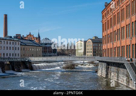 Die alte Industrielandschaft und der Fluss Motala im Frühling in Norrköping, Schweden. Stockfoto