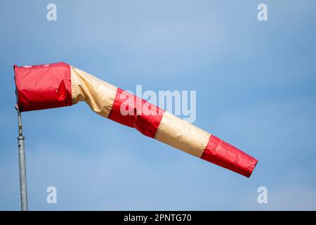 Rot-weiße Windsocke auf einem Flughafen, die Windrichtung und Windstärke anzeigt, Stockfoto