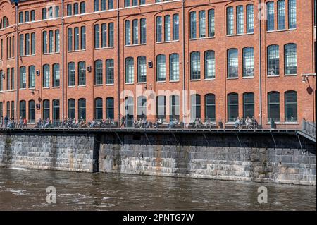 Sonnenbaden von Studenten in Kåkenhus in der alten Industrielandschaft im Frühling in Norrköping, Schweden. Stockfoto