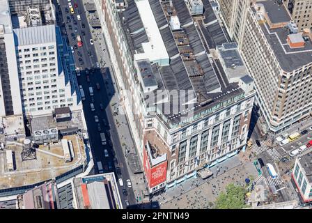 Macy's Herald Square, ein bekanntes Kaufhaus, hat nie das winzige Holdout in der Ecke erworben, obwohl sie eine dreistöckige Plakatwand managten. Stockfoto