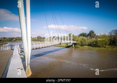 19.04.023 Lancaster, Lancashire, Vereinigtes Königreich. Die Lune Millennium Bridge ist eine Fußgängerbrücke mit Kabelhalterungen, die sich über den Fluss Lune in Lancaster, England erstreckt. Stockfoto