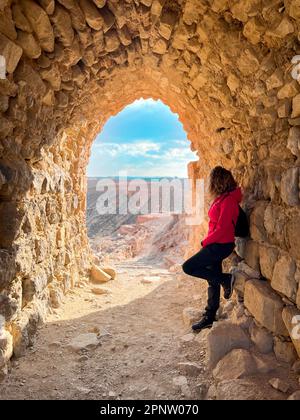 Steinbogen in Kerak Castle, Kreuzritter-Schloss in Kerak. Eine Frau von hinten schaut auf das Panorama. Stockfoto