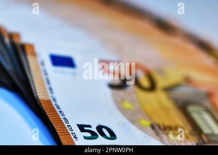 Konzept von vielen Euro: Ein Stapel gerollter 50-Euro-Scheine, die auf weißem Hintergrund liegen und Tausende von Euro in 50-Euro-Scheinen darstellen Stockfoto