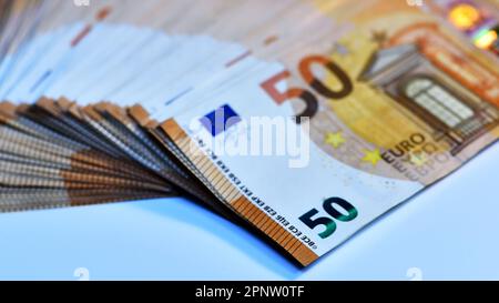 Konzept von vielen Euro: Ein Stapel gerollter 50-Euro-Scheine, die auf weißem Hintergrund liegen und Tausende von Euro in 50-Euro-Scheinen darstellen Stockfoto