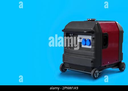 Tragbarer Benzingenerator auf blauem Hintergrund Stockfoto