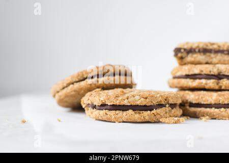 Haferkekse mit Schokoladenfüllung, hausgemachte Haferkekse gefüllt mit Schokoladenganache, dünne Haferkekse mit Schokoladenganache Stockfoto