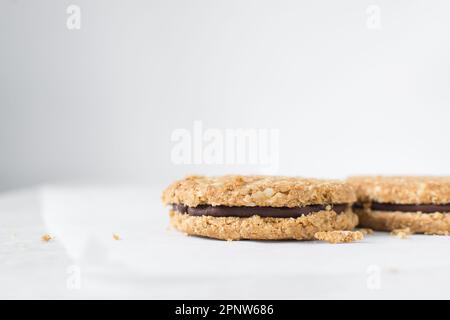 Haferkekse mit Schokoladenfüllung, hausgemachte Haferkekse gefüllt mit Schokoladenganache, dünne Haferkekse mit Schokoladenganache Stockfoto