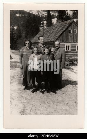 TSCHECHOSLOWAKISCHE SOZIALISTISCHE REPUBLIK, CA. 1950: Ein Jahrgangsfoto zeigt eine Gruppe von Menschen vor einem Holzhaus im Winter, ca. 1950er. Stockfoto