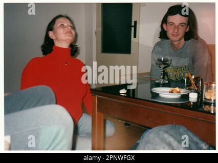 Das Retro-Foto zeigt, wie die Leute Wein am Tisch trinken. Stockfoto