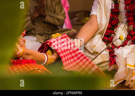 Hindu-Bengalisch-Hochzeitsritual, das von Braut und Bräutigam während der traditionellen Hochzeitszeremonie durchgeführt wird. Die Braut hat ihre Hand auf dem Bräutigam Stockfoto