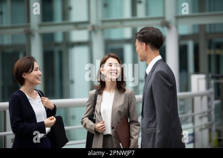 Zwei Geschäftsmänner und eine Geschäftsfrau, die sich unterhalten. Stockfoto