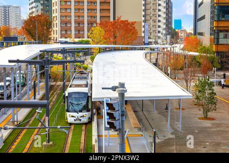 Kumamoto, Japan - Nov. 24 2022: Die Kumamoto City Tram ist eine bequeme öffentliche Verkehrsmittel, um in Kumamoto zu reisen Stockfoto