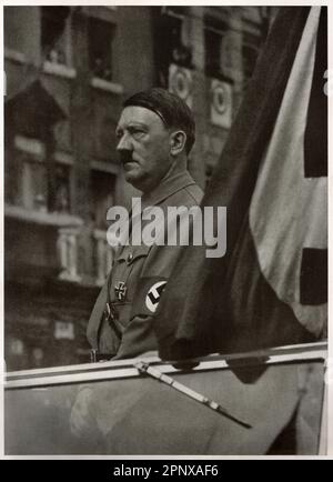 Der deutsche Führer Adolf Hitler steht in seinem Cabrio. Reproduktion antiker Fotos. Stockfoto