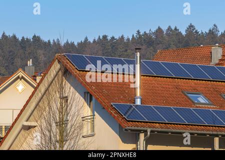 Freistehendes Haus mit Sonnenkollektoren auf dem Dach und Edelstahlschornstein Stockfoto