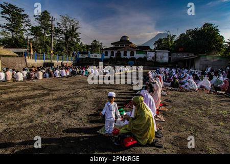 Sleman, Yogyakarta, Indonesien. 21. April 2023. Indonesische Muslime beten Eid al-Fitr 1944 Hijriyah mit dem Berg Merapi im Hintergrund, in Kaliurang, Sleman, Yogyakarta, Indonesien, Freitag, 21. April 2023 in Yogyakarta, Indonesien. Moslems auf der ganzen Welt feiern Eid mit ihren Familien mit Partys zum Ende des Ramadan, des heiligen Monats des Fastens. (Kreditbild: © Slamet Riyadi/ZUMA Press Wire) NUR REDAKTIONELLE VERWENDUNG! Nicht für den kommerziellen GEBRAUCH! Stockfoto