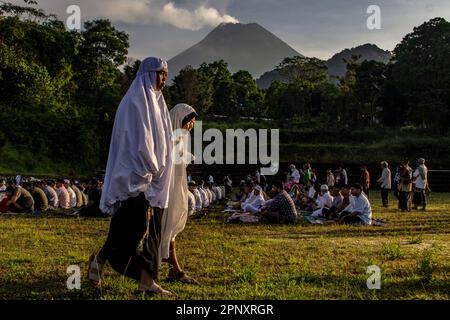 Sleman, Yogyakarta, Indonesien. 21. April 2023. Zwei indonesische muslimische Frauen gehen zu Fuß, um Eid al-Fitr 1944 Hijriyah Gebete mit Mount Merapi im Hintergrund in Kaliurang, Sleman, Yogyakarta, Indonesien, Freitag, 21. April 2023 in Yogyakarta, Indonesien. Moslems auf der ganzen Welt feiern Eid mit ihren Familien mit Partys zum Ende des Ramadan, des heiligen Monats des Fastens. (Kreditbild: © Slamet Riyadi/ZUMA Press Wire) NUR REDAKTIONELLE VERWENDUNG! Nicht für den kommerziellen GEBRAUCH! Stockfoto