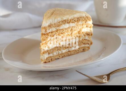Ein Stück Honigkuchen liegt in einer Untertasse auf dem Tisch Stockfoto