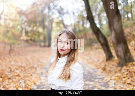 Junge Blondine im Herbstpark Stockfoto