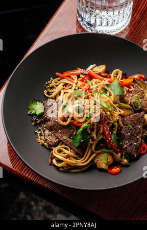 asiatische Nudeln mit Rindfleisch und Gemüse. Speisekarte des Restaurants Stockfoto