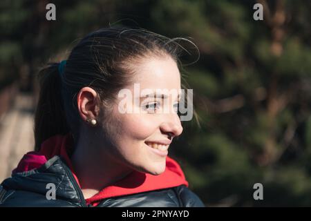 Porträt einer blauäugigen jungen Frau, die in der Natur lächelt Stockfoto